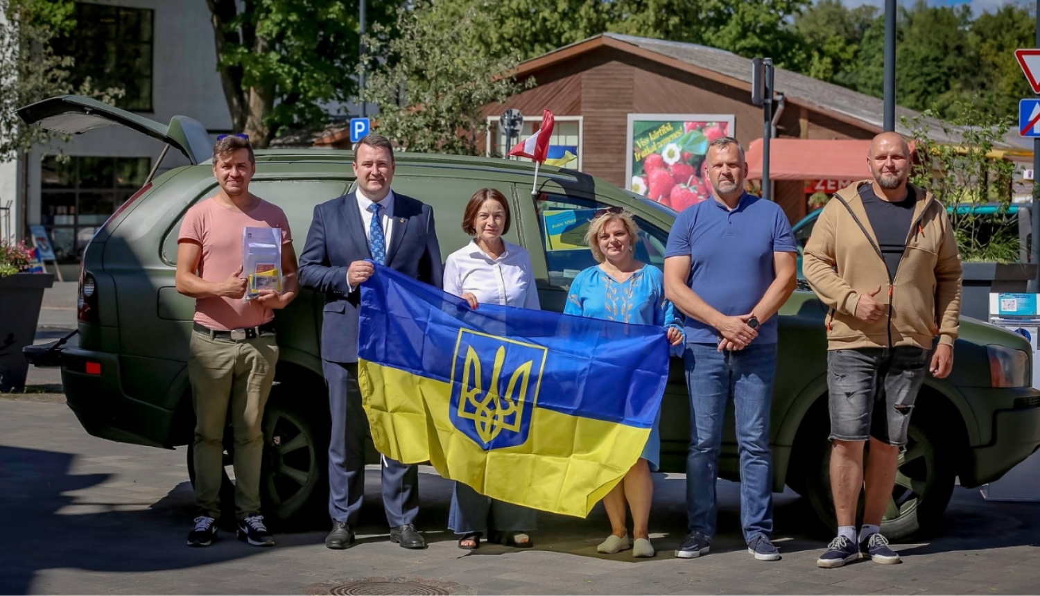 kopbilde ar Ukrainas karogu pie mašīnas, ko vedīs uz Ukrainu